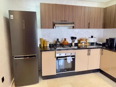a kitchen with a refrigerator and a stove at Appartement de Luxe près du CFC et de l Hôpital Cheikh Khalifa in Casablanca