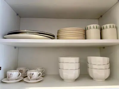a shelf with plates and cups and bowls at Appartement de Luxe près du CFC et de l Hôpital Cheikh Khalifa in Casablanca