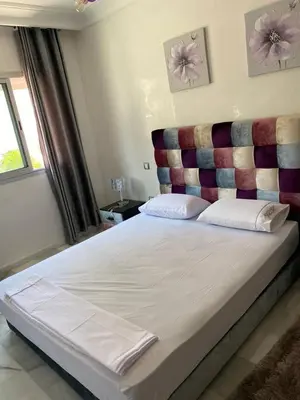 a bedroom with a large bed with a large headboard at Appartement pied sur mer in Mohammedia