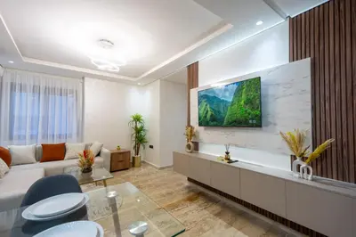 a living room with a couch and a tv on a wall at Magnificent apartment 2 in Casablanca