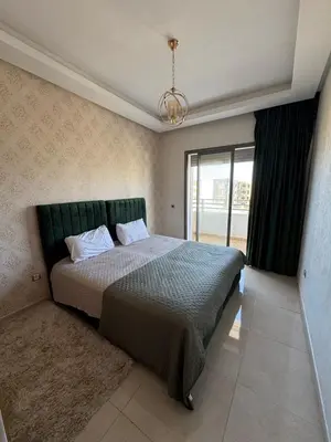 a bedroom with a bed with a green headboard at Luxury apartments in Mansouria