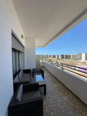 a balcony with couches and tables on a building at Luxury apartments in Mansouria