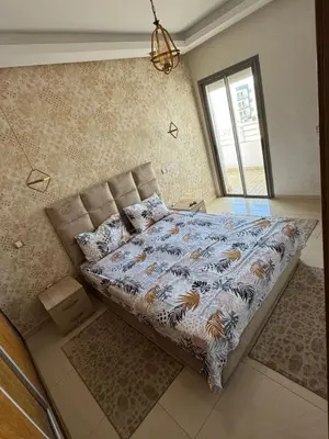 a bedroom with a bed in a room with a window at Luxury apartments in Mansouria