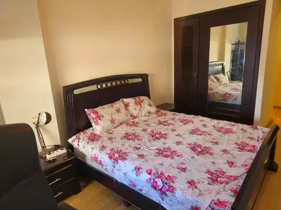 a bedroom with a bed with a floral comforter and a mirror at Appartement au centre-ville, calme et lumineux in Casablanca