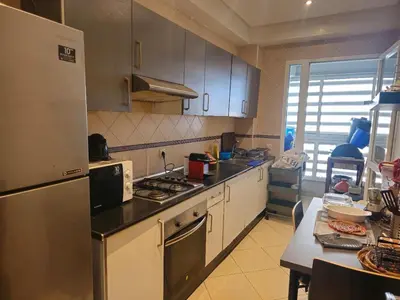 a kitchen with a refrigerator and a stove top oven at Appartement au centre-ville, calme et lumineux in Casablanca
