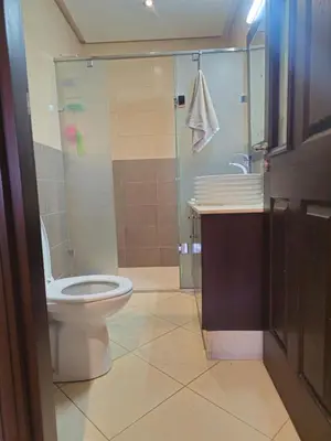 a bathroom with a toilet and a glass shower at Appartement au centre-ville, calme et lumineux in Casablanca