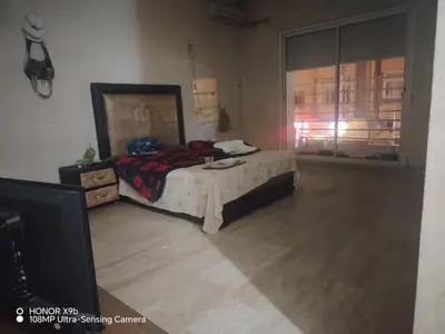 a bedroom with a bed and a dresser and a window at Apparttement BOUCHRA in Casablanca