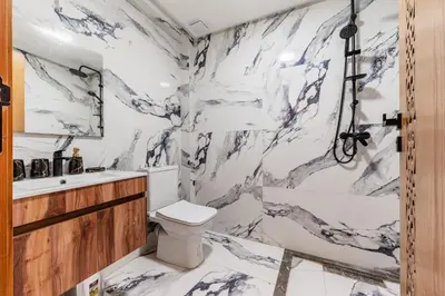 a bathroom with a toilet and a marble wall at Contemporary Hideaway Design and Tranquility in Casablanca