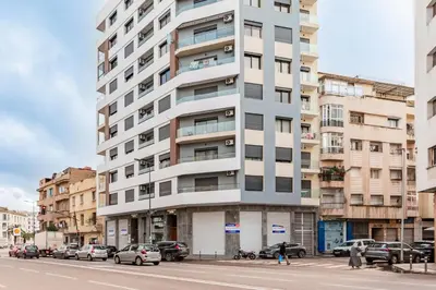a tall white apartment building on a city street at Contemporary Hideaway Design and Tranquility in Casablanca