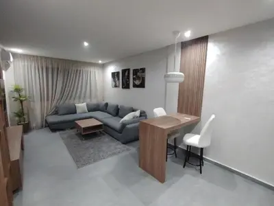 a living room with a blue couch and a table at Un studio luxueux au centre de Casablanca in Casablanca
