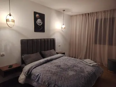 a bedroom with a large bed and two lights at Un studio luxueux au centre de Casablanca in Casablanca