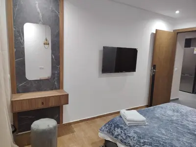 a room with a bed and a tv on a wall at Un studio luxueux au centre de Casablanca in Casablanca