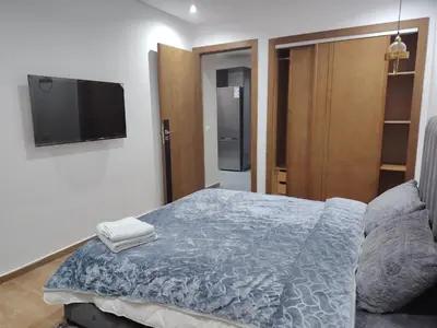 a bedroom with a bed and a flat screen tv at Un studio luxueux au centre de Casablanca in Casablanca