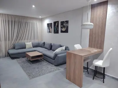 a living room with a blue couch and a table at Un studio luxueux au centre de Casablanca in Casablanca