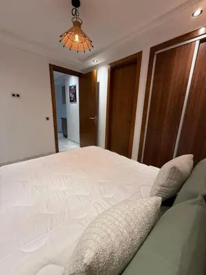 a bedroom with a large white bed with pillows at Élégant studio moderne Anoual Maarif Casablanca parfaitement équipé in Casablanca