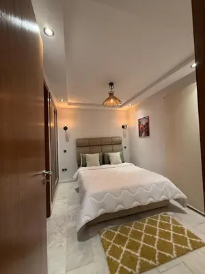 a bedroom with a large bed and a rug at Élégant studio moderne Anoual Maarif Casablanca parfaitement équipé in Casablanca