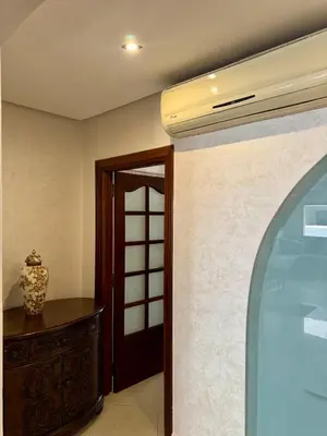 a room with a door and a vase on a table at Spacious athène apartment in Maarif