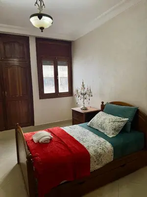 a bedroom with a bed with a red blanket at Spacious athène apartment in Maarif