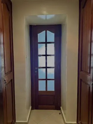 an empty hallway with a door with a window at Spacious athène apartment in Maarif
