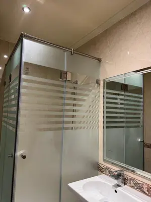 a bathroom with a shower and a sink and a mirror at Spacious athène apartment in Maarif