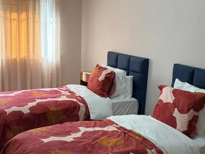 a bedroom with two beds and a chair at Très joli appartement très calme, très agréables pour un séjour en famille au haut Agdal Rabat in Rabat