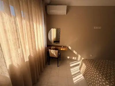 a bedroom with a bed and a desk next to a window at Très joli appartement très calme, très agréables pour un séjour en famille au haut Agdal Rabat in Rabat
