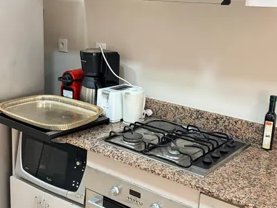 a kitchen counter with a stove and a microwave at Très joli appartement très calme, très agréables pour un séjour en famille au haut Agdal Rabat in Rabat