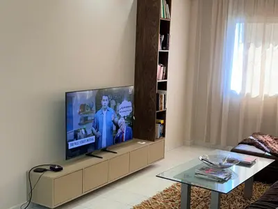 a living room with a flat screen tv on a wall at Très joli appartement très calme, très agréables pour un séjour en famille au haut Agdal Rabat in Rabat