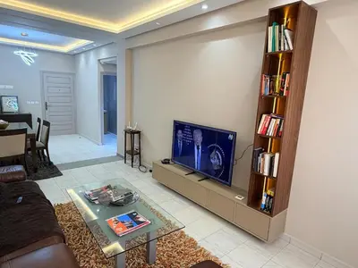 a living room with a couch and a tv at Très joli appartement très calme, très agréables pour un séjour en famille au haut Agdal Rabat in Rabat