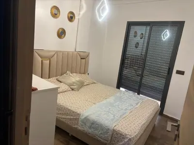 a small bedroom with a bed and a window at Cozy Apartement next to the airport in Deroua