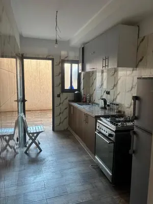 a kitchen with a stove and a refrigerator at Cozy Apartement next to the airport in Deroua