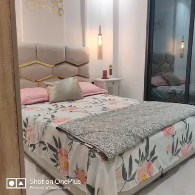 a bedroom with a bed with a large mirror at Appartement near the airport in Deroua