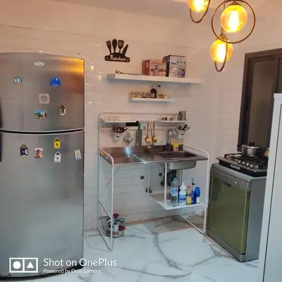 a kitchen with a stainless steel refrigerator and a sink at Appartement near the airport in Deroua