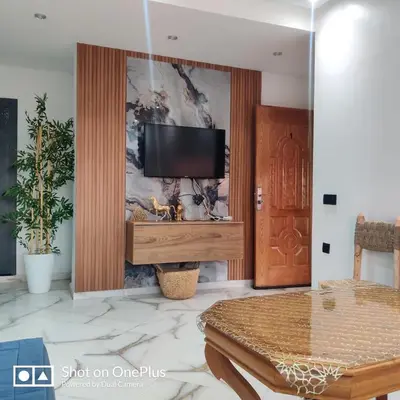 a living room with a flat screen tv on a wall at Appartement near the airport in Deroua
