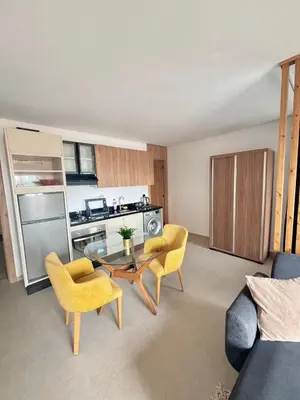 a living room with a table and chairs and a kitchen at superbe loft au cœur de la ville in Casablanca