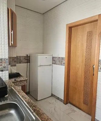 a kitchen with a white refrigerator and a sink at Hassan in Rabat