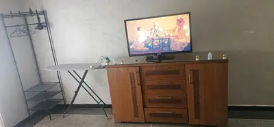 a tv on top of a wooden entertainment center with a table at Hassan in Rabat