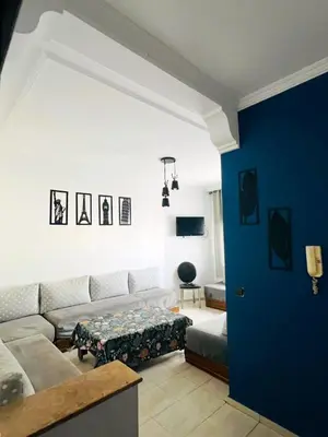 a living room with a couch and a blue wall at lodgeocean in Rabat