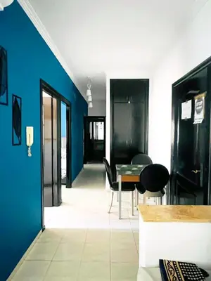 a dining room with blue walls and a table and chairs at lodgeocean in Rabat