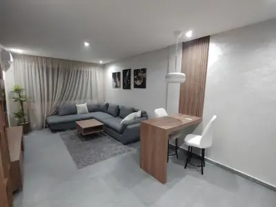 a living room with a blue couch and a table at Studio luxueux in Roches Noires