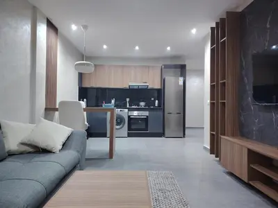 a living room with a couch and a kitchen at Studio luxueux in Roches Noires