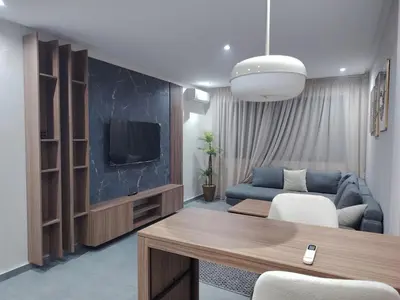 a living room with a blue couch and a tv at Studio luxueux in Roches Noires