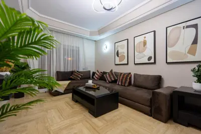 a living room with a brown couch and a table at Bel appartement piscine & plage - Mohammedia in Mohammedia