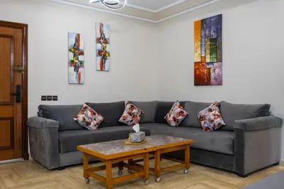 a living room with a couch and a table at Bel appartement piscine & plage - Mohammedia in Mohammedia