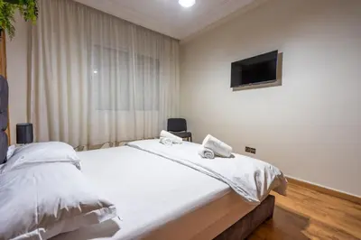 a bedroom with a bed with a tv on the wall at Bel appartement piscine & plage - Mohammedia in Mohammedia