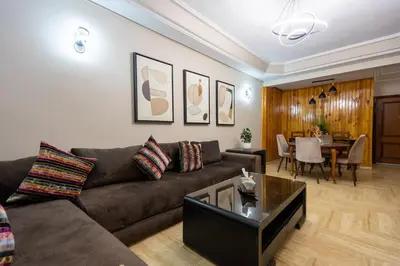 a living room with a couch and a table at Bel appartement piscine & plage - Mohammedia in Mohammedia