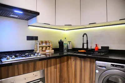 a kitchen with a stove and a sink and a dishwasher at Socrates Prestige, quartier Les Princesses in Casablanca