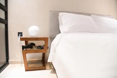 a bedroom with a bed and a night stand with a phone at Socrates Prestige, quartier Les Princesses in Casablanca