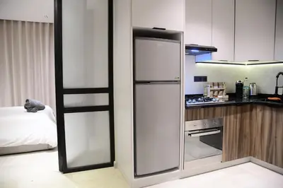 a kitchen with a stainless steel refrigerator in a room at Socrates Prestige, quartier Les Princesses in Casablanca