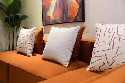 a couch with two pillows on it with a painting at Socrates Prestige, quartier Les Princesses in Casablanca